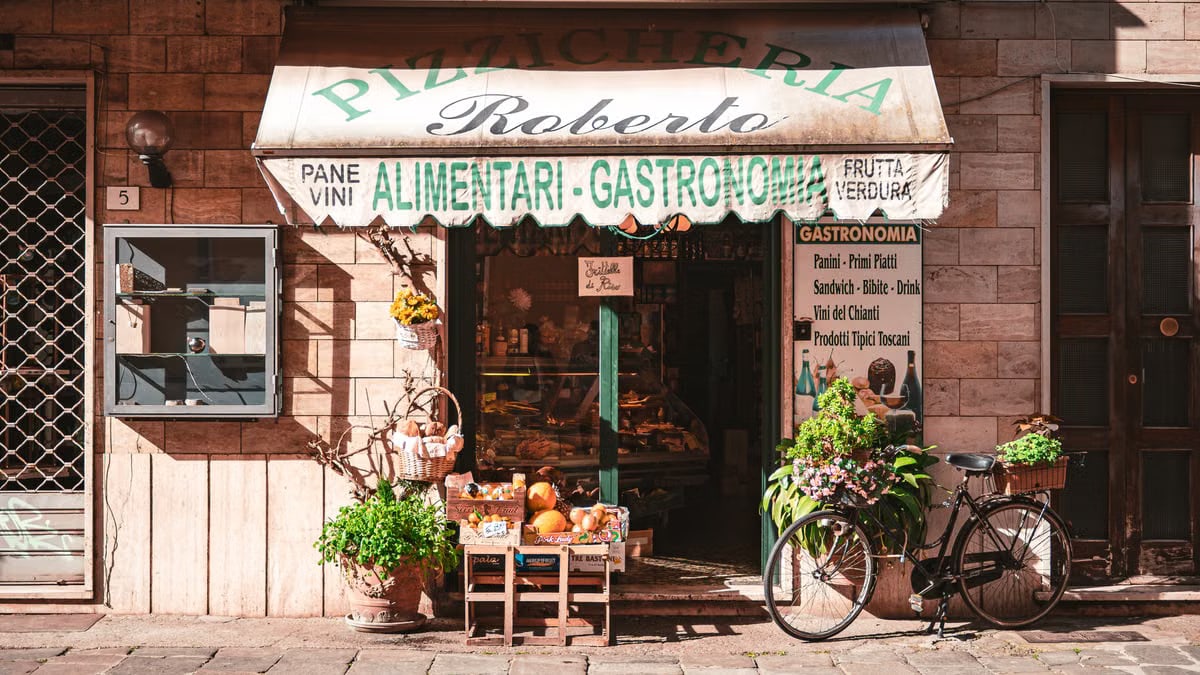 A quaint Italian grocery store with fresh produce and a vintage bicycle outside, offering local delicacies.